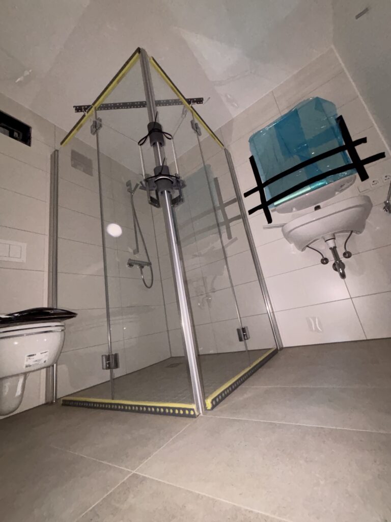 Vorgefertigtes Badezimmermodul mit Dusche, WC und Waschbecken, bereit für den Einbau im Wohngebäude.
